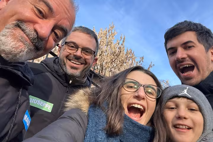 Group of five smiling people taking a selfie outdoors in Milan during a walking tour