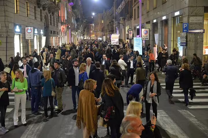 Vibrant crowd enjoying Milan's lively streets during a private night tour, showcasing the city's dynamic night scene.