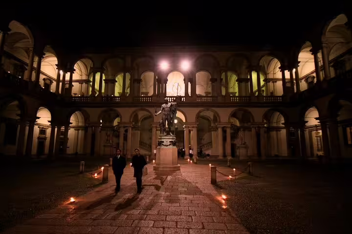 Elegant courtyard of Milan's historic palace illuminated at night, offering a serene atmosphere for private tours.