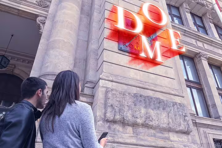 Two people looking at glowing DO ME street art on Milan building facade during outdoor exploration game
