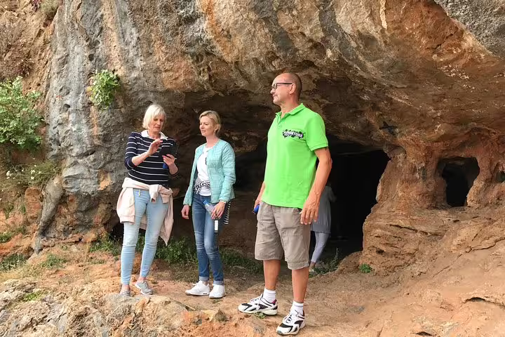 Tourists standing at the entrance of Milatos Cave, a highlight of the Spinalonga and Olive Oil Tasting tour.