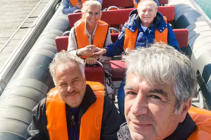 Group enjoying a private boat tour from Milfontes to Algarve with life jackets, highlighting the scenic Benagil caves adventure.