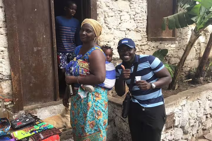 Friendly local interaction with a family in traditional attire during a cultural tour in Mindelo, São Vicente.