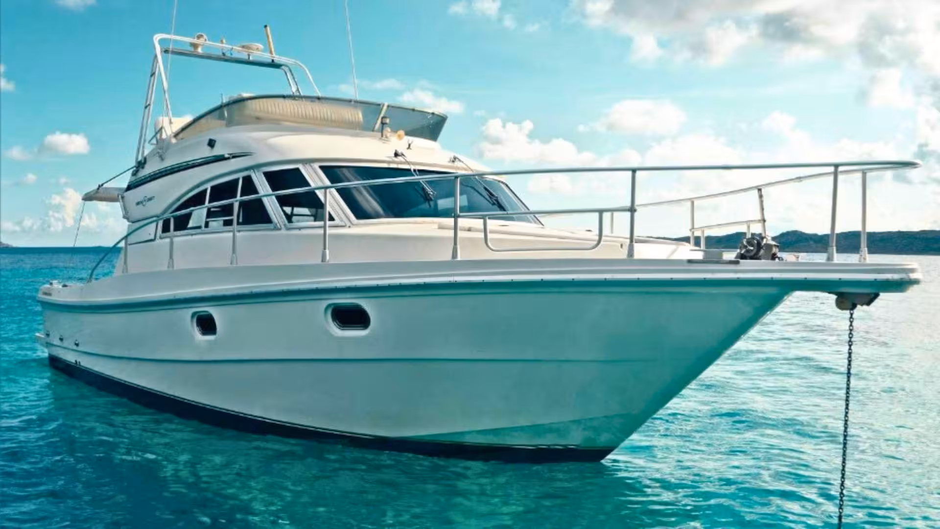 A sleek mini yacht anchored in the clear waters of the La Maddalena archipelago, Sardinia.