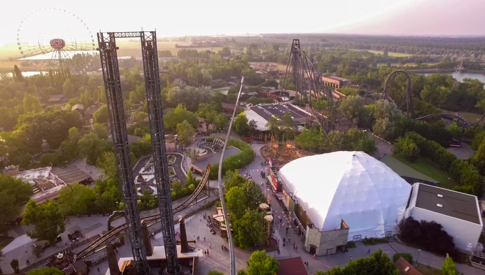 Aerial view of Mirabilandia Amusement Park with roller coasters and towers at sunset, open-date entry
