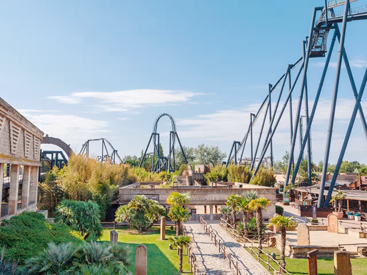 Panoramic view of Mirabilandia theme park in Ravenna with towering roller coasters and palm-lined pathways