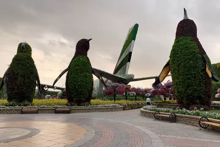 Miracle Garden Dubai penguin topiaries and Emirates A380 flower display on Fujairah transportation tour