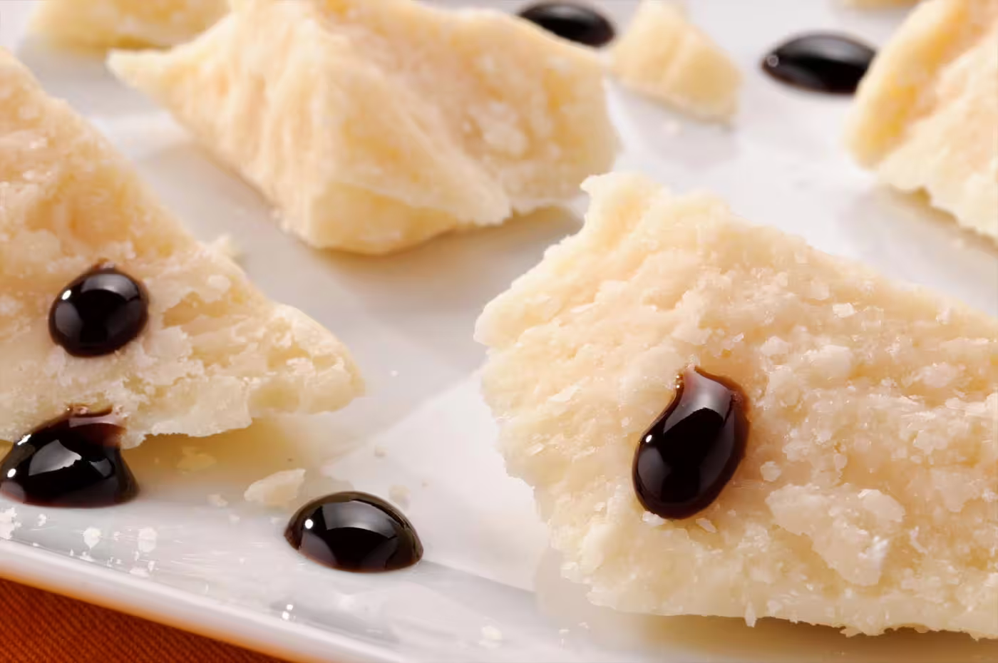 Parmesan cheese flakes with drops of traditional balsamic vinegar during Modena cellar tasting experience