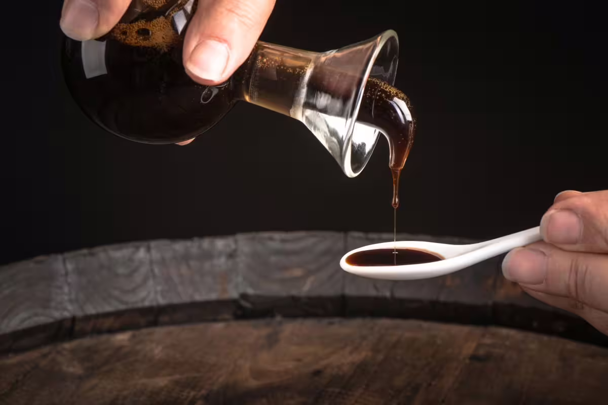 Traditional balsamic vinegar poured for tasting in a Modena acetaia cellar tour with typical lunch experience