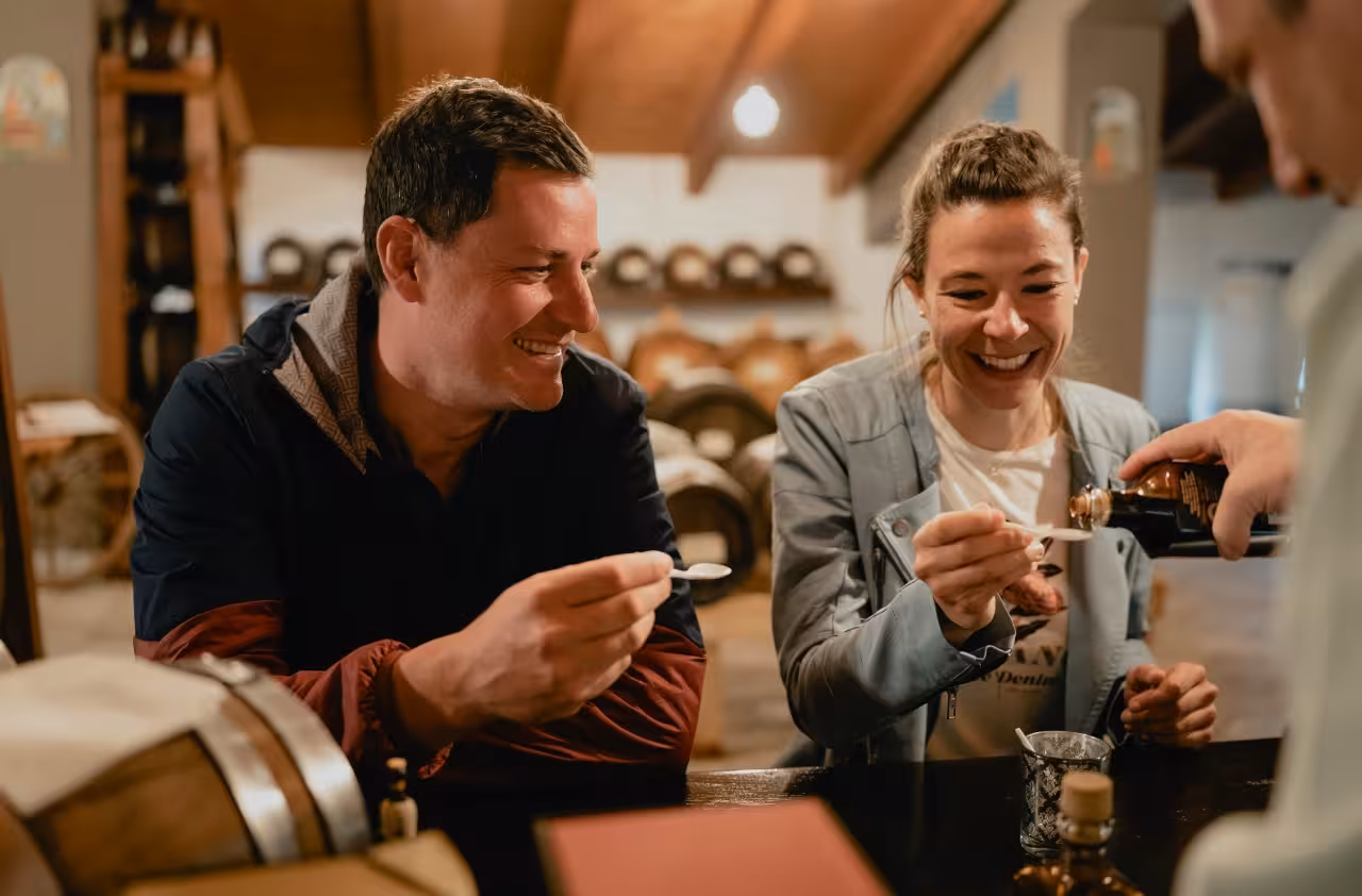 Guests tasting traditional balsamic vinegar in Modena acetaia, sampling drops on spoons during guided tour