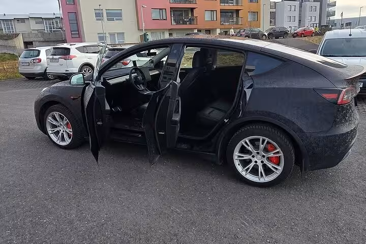 Open doors of modern black vehicle in Reykjavik, ideal for cruise port transfers to Keflavik, showcasing spacious interior.