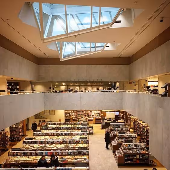 Modern bookstore interior with geometric skylight, showcasing innovative architecture and inviting atmosphere.