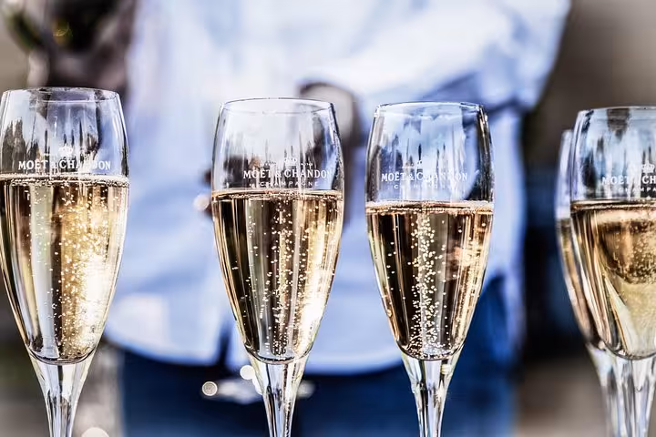Moet Chandon champagne flutes filled with sparkling champagne held by a server in Epernay