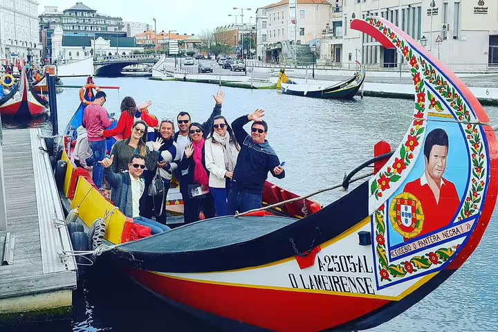 Tourists enjoying a traditional moliceiro boat ride in Aveiro, Portugal, highlighting a stop on the Lisbon to Porto transfer.