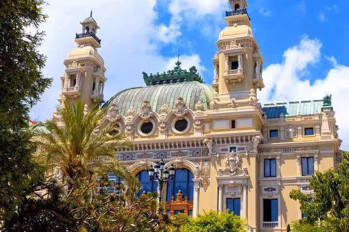 Ornate Belle Époque casino building with green copper dome and decorative towers in Monaco
