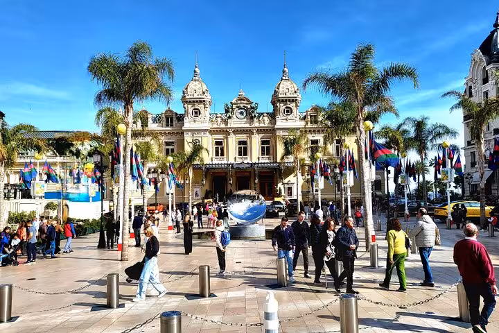 Monaco's Casino Square bustling with tourists and iconic architecture on a sunny day, perfect for a luxury tour.