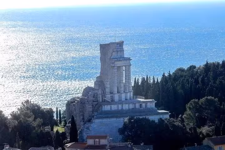 Ancient Roman ruins on a coastal cliff overlooking the shimmering Mediterranean Sea near Monaco