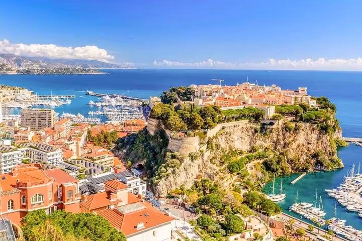 Breathtaking aerial view of Monaco's coastline and harbor, featuring luxury yachts and the majestic Prince's Palace.