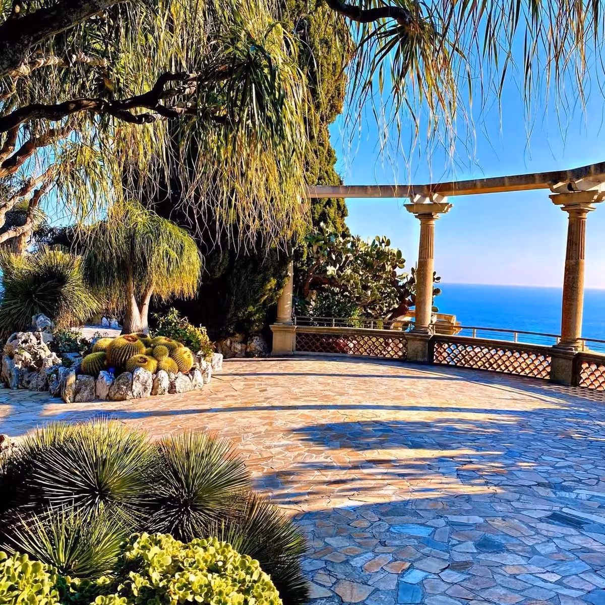 Stone terrace with cacti and pergola overlooking the blue Mediterranean Sea in Monaco