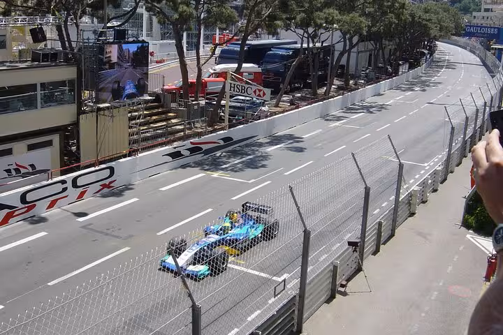 Formula 1 race car speeding through Monaco Grand Prix street circuit with HSBC banner