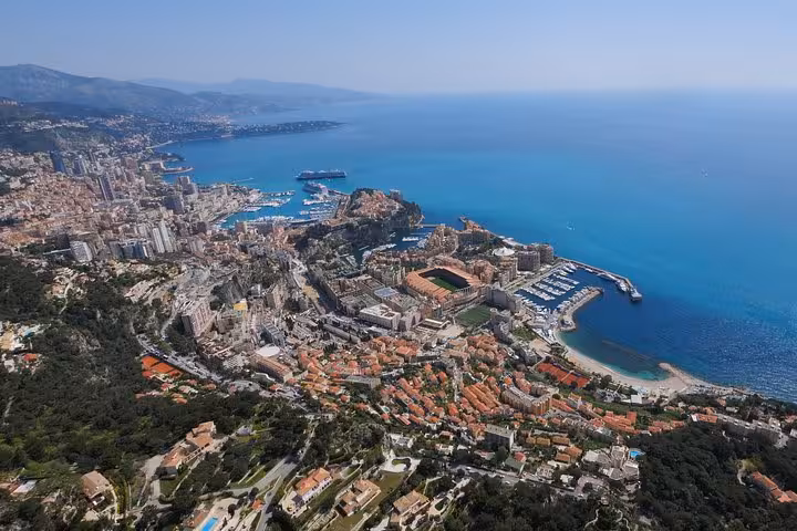 Aerial view of Monaco and French Riviera coastline with turquoise Mediterranean Sea and dense cityscape