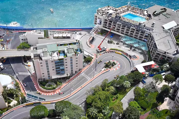 Aerial view of Monaco's hairpin turn with Formula 1 cars racing along the French Riviera coastline