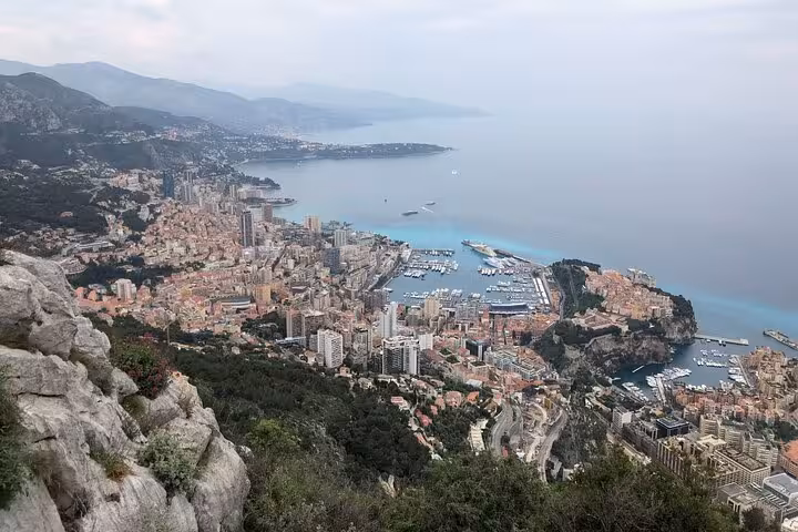 Aerial panoramic view of Monaco cityscape, harbor with yachts, and Mediterranean coastline from hilltop