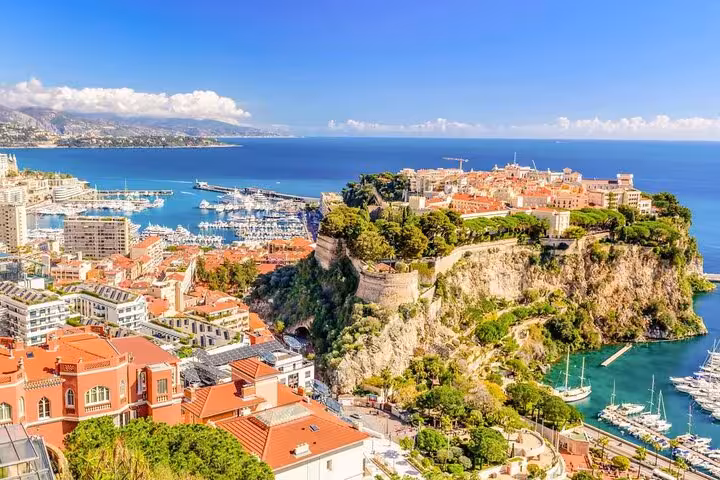 Scenic view of Monaco's harbor and medieval architecture on a cliff, ideal for French Riviera East Coast private tours.