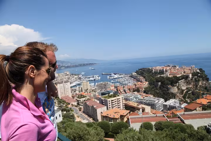 Couple overlooking Monaco harbor and Monte-Carlo cityscape from scenic hilltop viewpoint