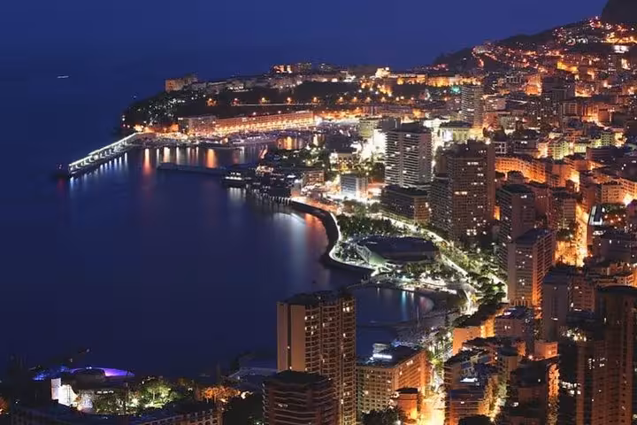 Monaco coastline illuminated at night with city lights reflecting on the Mediterranean Sea