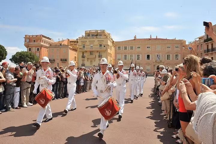 Monaco palace guard changing ceremony with marching drummers in white uniforms before crowd of tourists