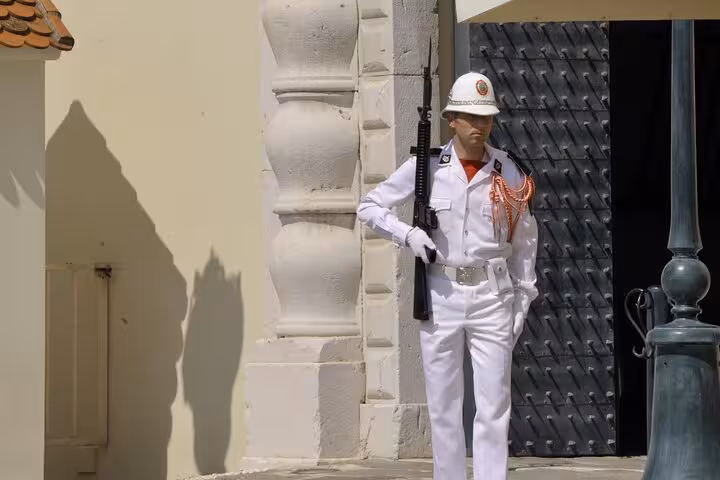Palace guard in white uniform holding rifle at Monaco Prince's Palace entrance