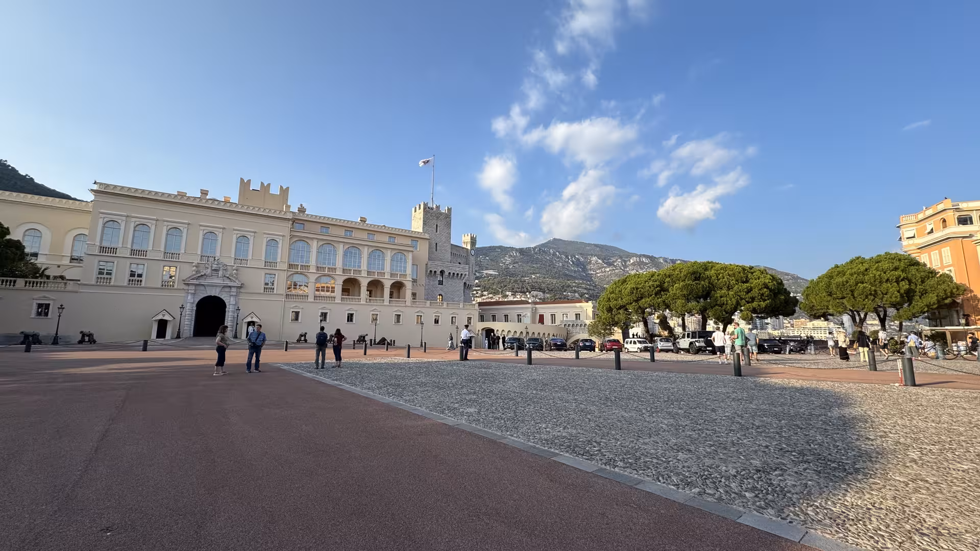 Prince's Palace of Monaco courtyard with medieval tower and Monegasque flag on sunny day