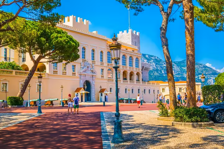 Explore the grandeur of Monaco's Prince's Palace amidst a vibrant square and lush greenery on a private tour.