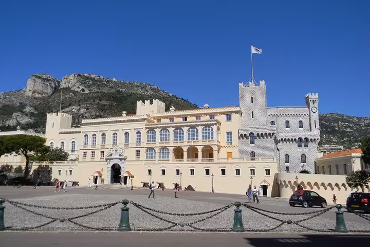 Prince's Palace of Monaco with medieval towers and cobblestone square against mountain backdrop