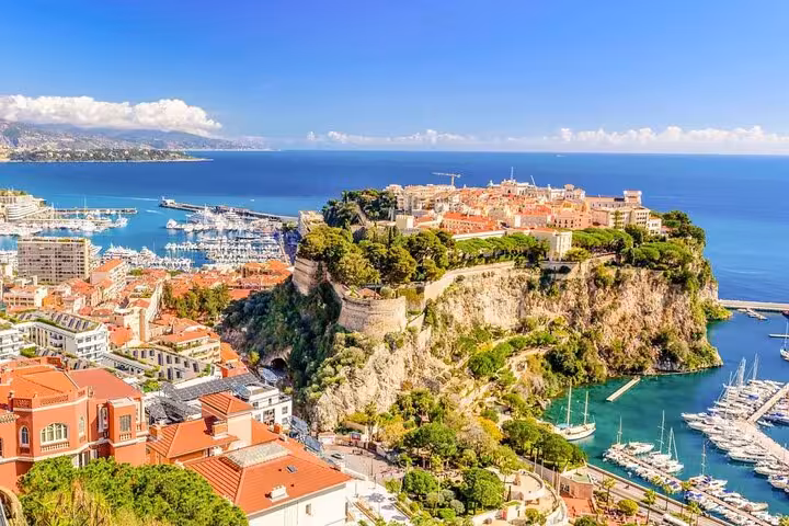 Scenic view of Monaco's cliffside old town and harbor, showcasing the stunning Riviera coastline on a private tour.