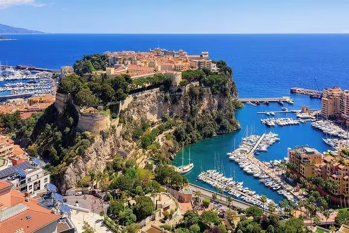 Aerial view of Monaco's historic rock fortress overlooking a luxury yacht marina on the French Riviera