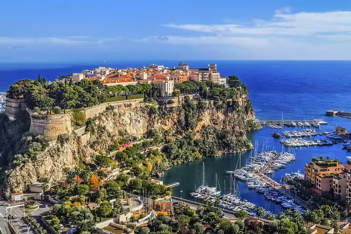 Aerial view of Monaco's historic Rock of Monaco with Prince's Palace, marina full of yachts, and Mediterranean Sea