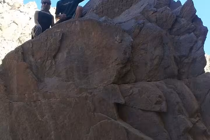Visitors on rocky desert cliffs near Monastery of Saint Paul the Anchorite, Hurghada day trip in Eastern Desert