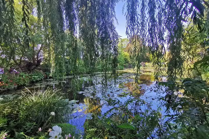 Monet’s Garden in Giverny with willow trees and water lily pond, scenic stop on a private Paris to Rouen tour