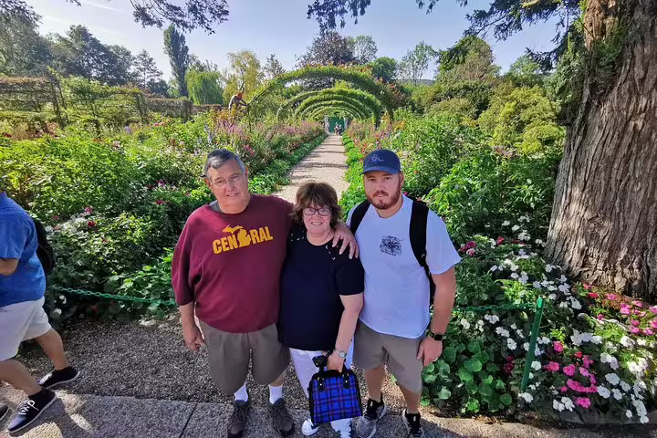 Visitors posing in the rose garden arches at Monet’s Giverny, highlight of a private Paris day trip to Rouen