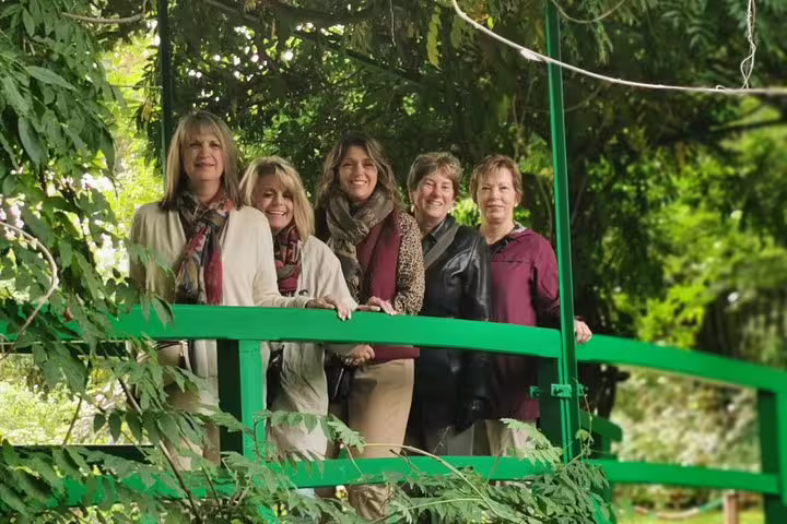 Visitors on Monet’s iconic green Japanese bridge in Giverny, part of a private Giverny and Rouen tour