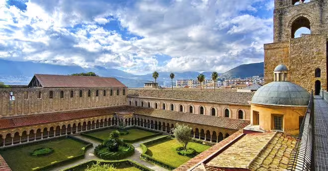 Panoramic view of Monreale Cathedral cloister gardens and bell tower overlooking Palermo valley on a private day trip