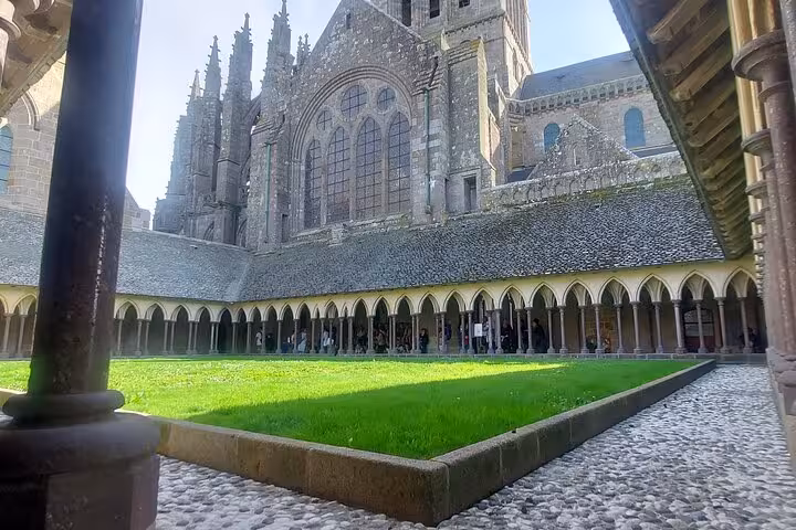 Gothic Mont Saint Michel Abbey seen over the cloister garden, featured stop on small group day tour with luxury van