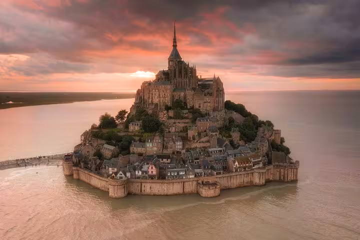 Aerial sunset view of Mont-Saint-Michel island abbey surrounded by tidal waters in Normandy, France