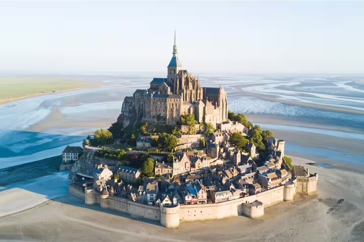 Aerial view of Mont Saint-Michel island abbey surrounded by tidal flats in Normandy, France
