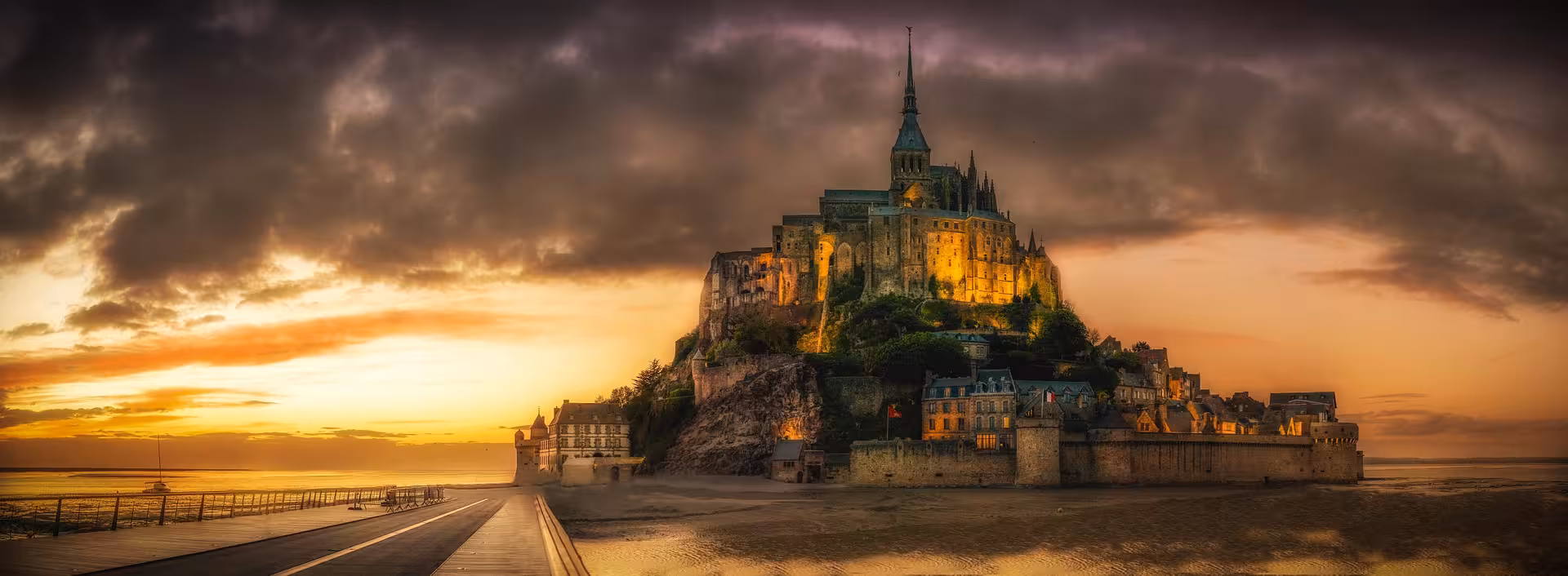 Sunset view of Mont Saint-Michel abbey on the tidal island, highlight of a VIP private luxury van tour