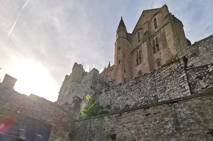 Low-angle view of Mont Saint-Michel Abbey walls, highlight of a private guided day tour from Paris
