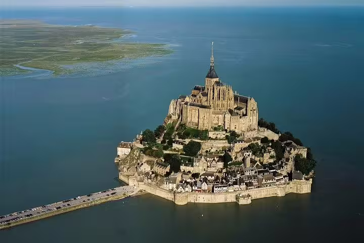 Aerial view of Mont Saint-Michel island and causeway in Normandy, must-see stop on a private day tour from Paris