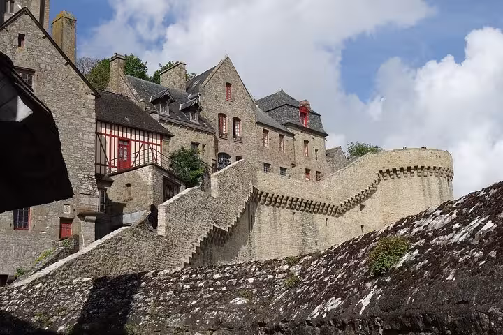 Stone ramparts and medieval houses on Mont Saint-Michel, Normandy stop on small group day trip by luxury van